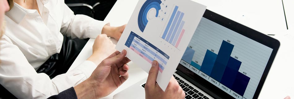 Business professionals discussing data charts and graphs in a modern office setting.